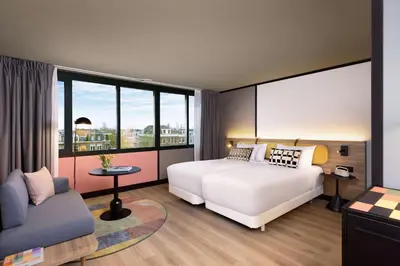 a bedroom with a bed and a couch and a window at Avani Museum Quarter Amsterdam Hotel in Amsterdam