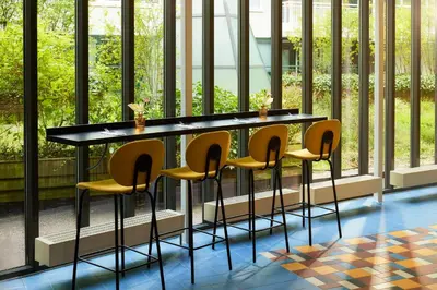 a table and chairs in a room with windows at Avani Museum Quarter Amsterdam Hotel in Amsterdam