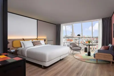 a bedroom with a white bed and a large window at Avani Museum Quarter Amsterdam Hotel in Amsterdam