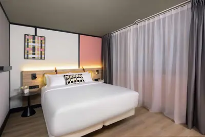 a bedroom with a large white bed and a window at Avani Museum Quarter Amsterdam Hotel in Amsterdam