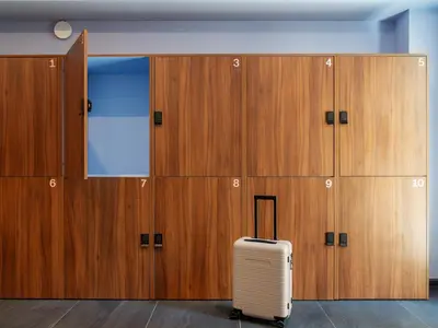 a suitcase sits in front of a row of lockers at YAYS Amsterdam Prince Island by Numa in Amsterdam