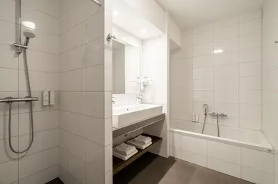 a bathroom with a sink and a tub and a shower at YAYS Amsterdam Prince Island by Numa in Amsterdam