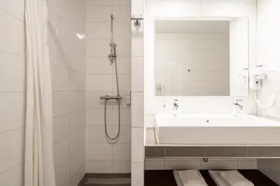 a bathroom with a tub and a sink and a mirror at YAYS Amsterdam Prince Island by Numa in Amsterdam
