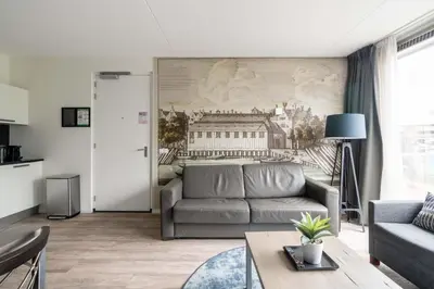 a living room with a couch and a painting on the wall at YAYS Amsterdam Prince Island by Numa in Amsterdam