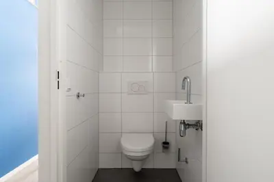a white bathroom with a toilet and a sink at YAYS Amsterdam Prince Island by Numa in Amsterdam