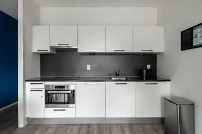 a kitchen with white cabinets and a sink at YAYS Amsterdam Prince Island by Numa in Amsterdam