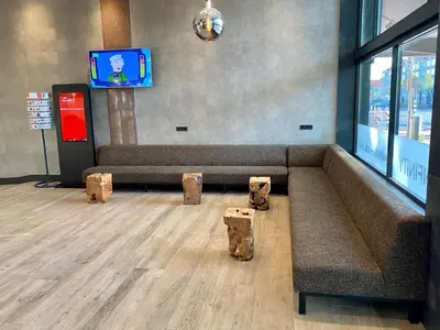 a waiting room with a couch and a tv at XO Hotels Infinity in Amsterdam