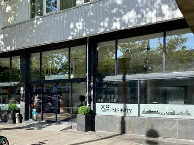 a glass building with a vos infinity sign on it at XO Hotels Infinity in Amsterdam