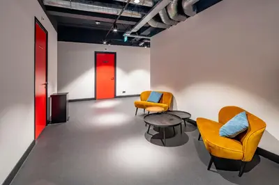 a room with two chairs and a table and a red door at City Trip Hostels Amsterdam-Zaandam in Zaandam