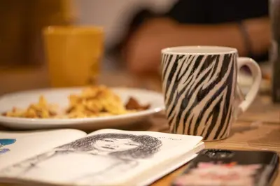 a table with a plate of food and a coffee mug at City Trip Hostels Amsterdam-Zaandam in Zaandam