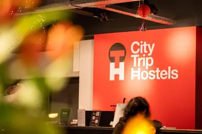 a woman sitting at a desk in front of a sign at City Trip Hostels Amsterdam-Zaandam in Zaandam