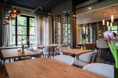 a restaurant with tables and chairs and windows at Résidence Lage Vuursche in Lage-Vuursche