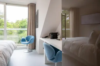 a hotel room with a bed and a desk and chairs at blooming in Bergen