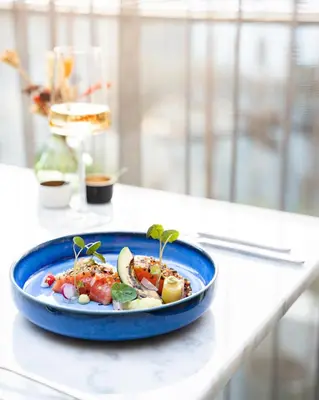 a blue plate of food on a table at blooming in Bergen