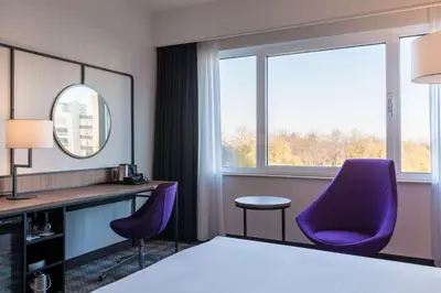 a hotel room with purple chairs and a mirror at Radisson Blu Hotel Amsterdam Airport, Schiphol in Schiphol
