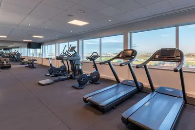 a gym with rows of tread machines in a building at Radisson Blu Hotel Amsterdam Airport, Schiphol in Schiphol