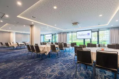 a conference room with tables and chairs and a projection screen at Radisson Blu Hotel Amsterdam Airport, Schiphol in Schiphol