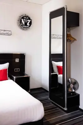 a room with two beds and a mirror in it at Backstage Hotel Amsterdam in Amsterdam