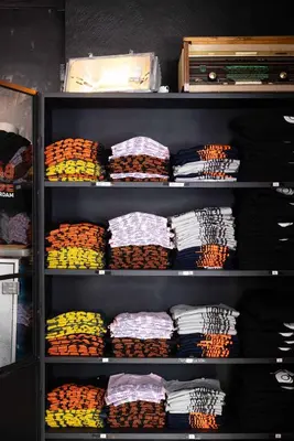 a shelf filled with lots of shirts at Backstage Hotel Amsterdam in Amsterdam