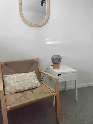 a room with a chair and a table with a mirror at Tiny beachhouse - free parking in Noordwijk