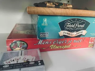 two boxes of different types of playing cards on a shelf at Tiny beachhouse - free parking in Noordwijk