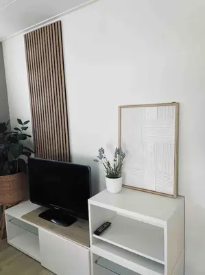 a living room with a tv on a white cabinet at Tiny beachhouse - free parking in Noordwijk