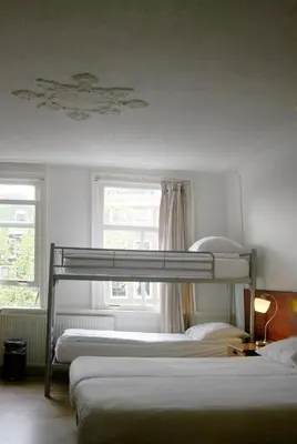 a bedroom with two bunk beds and a window at Hostel The Veteran in Amsterdam