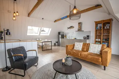 a living room with a couch and a table at Bodhi Beach House in Egmond aan Zee