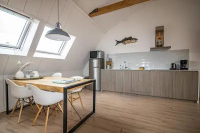 a kitchen with a table and chairs in a room at Bodhi Beach House in Egmond aan Zee