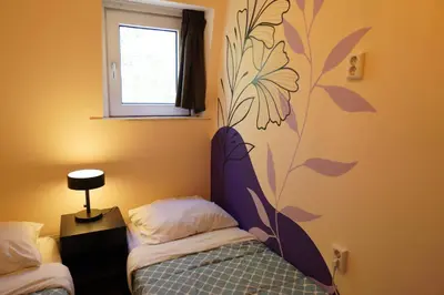 a bedroom with two beds and a flower mural on the wall at Onefam Amstel in Amsterdam
