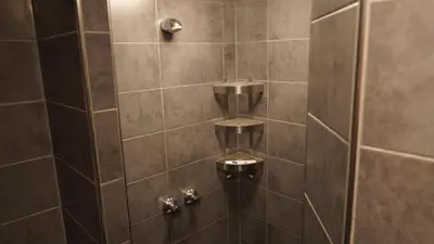 a bathroom with a shower with brown tiles at Onefam Amstel in Amsterdam