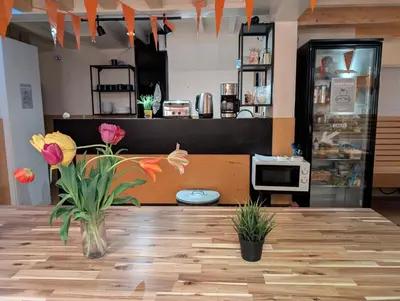 a store with a vase of flowers on a wooden floor at Onefam Amstel in Amsterdam