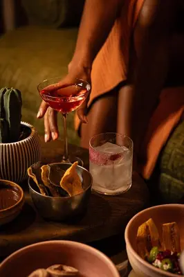a woman holding a glass of wine on a table with food at Renaissance Amsterdam Hotel in Amsterdam