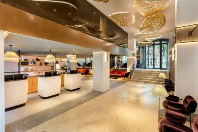 a lobby with a bar with chairs and tables at Renaissance Amsterdam Hotel in Amsterdam
