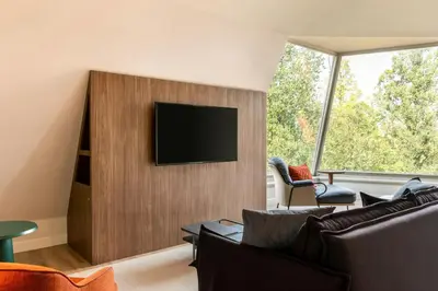 a living room with a flat screen tv on a wall at Renaissance Amsterdam Hotel in Amsterdam