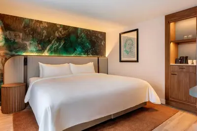 a bedroom with a large white bed and a painting at Renaissance Amsterdam Hotel in Amsterdam