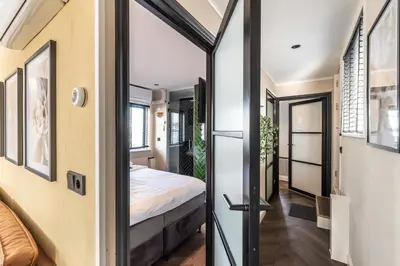 a bedroom with a bed and a door leading into a room at Beautiful Water Villa, near Schiphol and Amsterdam in Aalsmeer