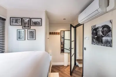 a bedroom with a white bed and pictures on the wall at Beautiful Water Villa, near Schiphol and Amsterdam in Aalsmeer