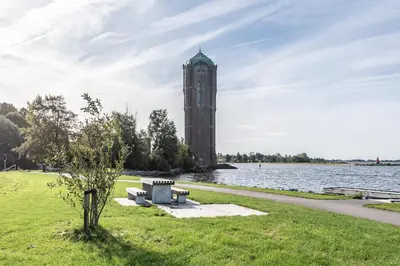 a clock tower in a park next to a body of water at Beautiful Water Villa, near Schiphol and Amsterdam in Aalsmeer