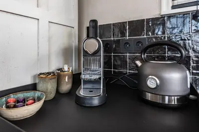 a kitchen counter with a tea kettle and a bowl of fruit at Beautiful Water Villa, near Schiphol and Amsterdam in Aalsmeer