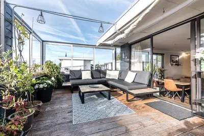 a living room with a couch and some plants at Beautiful Water Villa, near Schiphol and Amsterdam in Aalsmeer
