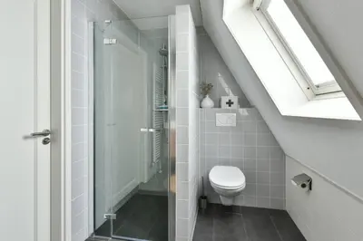 a white bathroom with a toilet and a shower at Have a nice stay! - Beachhouse Zonneweelde in Noordwijk