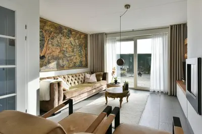 a living room with a couch and a table at Have a nice stay! - Beachhouse Zonneweelde in Noordwijk