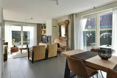a living room with a table and chairs and a dining room at Have a nice stay! - Beachhouse Zonneweelde in Noordwijk