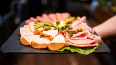 a plate with a sandwich with meat and vegetables at Royal Amsterdam Hotel in Amsterdam