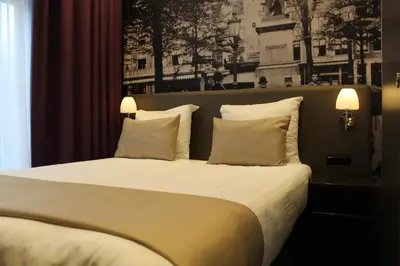 a bedroom with a large bed with white sheets and pillows at Royal Amsterdam Hotel in Amsterdam