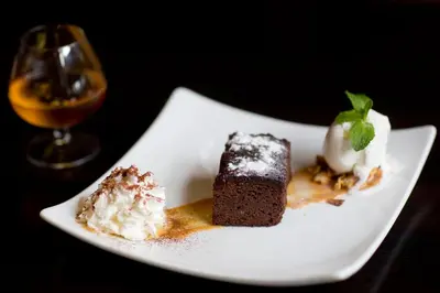 two pieces of cake and ice cream on a white plate at Royal Amsterdam Hotel in Amsterdam