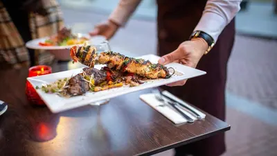 a person holding a plate of food on a table at Royal Amsterdam Hotel in Amsterdam