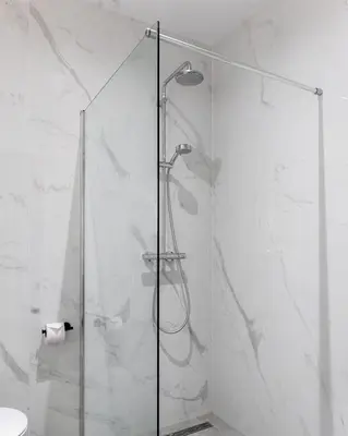 a shower with a glass door in a bathroom at HOTEL ALKMAAR - Bar & Restaurant - Meeting & Events in Alkmaar