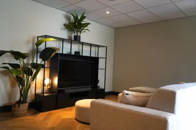 a living room with a couch and a flat screen tv at HOTEL ALKMAAR - Bar & Restaurant - Meeting & Events in Alkmaar